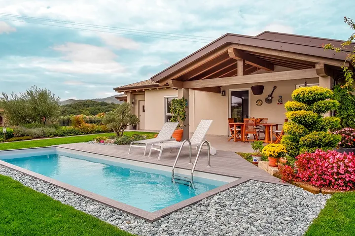 Area esterna con piscina, solarium e patio coperto di una villa