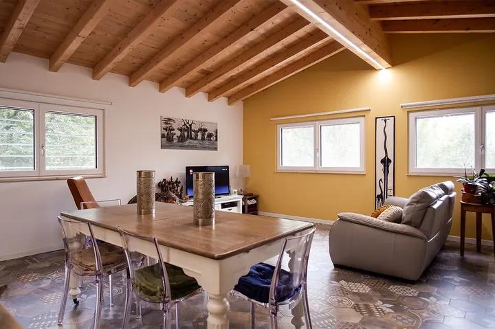 Interno di soggiorno con soffitto in legno a vista e arredi moderni